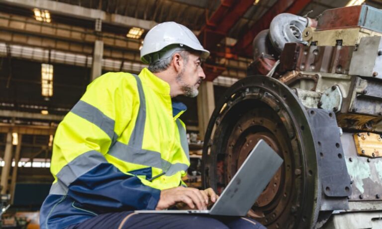 professional technician engineer with safety helmet checking machinery production equipment